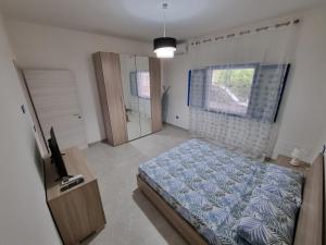 托雷拉皮罗Villetta Azzurra的一间卧室配有一张床、一台电视和一个窗口