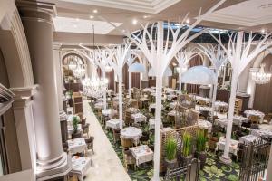 圣马洛格兰德酒店的一间设有白色桌子和吊灯的用餐室