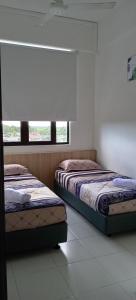 阿罗士打D'yana Imperio Homestay的两张床位于带窗户的房间内