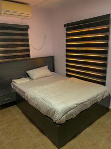 伊洛林Dabb Apartments的一间卧室配有一张大床和木制床头板