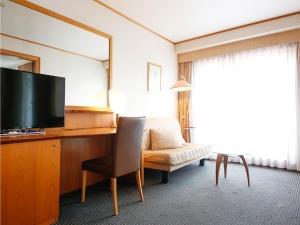 舞鹤市Hotel BELLMARE ホテルベルマーレ的酒店客房配有书桌、电视和椅子