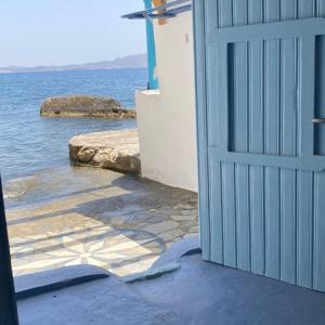 Klimathe monk seal boathouse的通向水边建筑物的蓝色门