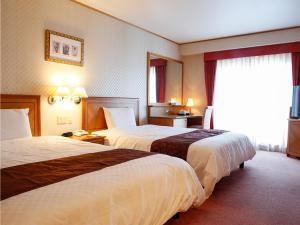 舞鹤市Hotel BELLMARE ホテルベルマーレ的酒店客房设有两张床和窗户。