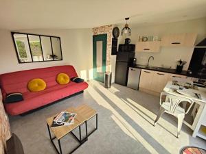 Appartement moderne en rez de jardin - La Cascade的一间带红色沙发的客厅和一间厨房