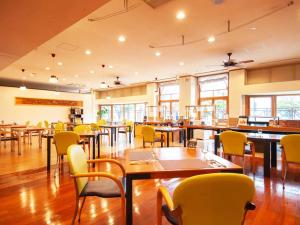 舞鹤市Hotel BELLMARE ホテルベルマーレ的用餐室配有桌子和黄色椅子