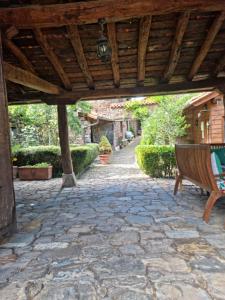 TudesLa Casa de las Chimeneas的石头天井,设有木凉棚下的长凳
