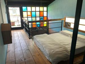 台南樂宅 1960 包棟民宿的一间卧室设有床铺和彩色玻璃窗