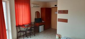 克兰内沃Hotel Morski Dar的小房间设有小桌子和红色窗帘