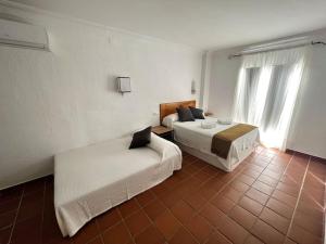 埃尔罗西奥Suite en el corazón de Doñana的一间卧室设有两张床和窗户。
