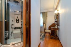 特罗吉尔Heritage Hotel Pasike的带淋浴的浴室和玻璃门