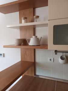 科巴里德City Nest Apartment的厨房配有木制架子和微波炉
