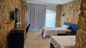 RizokarpasoBURHAN'S HOTEL的酒店客房设有两张床和电视。