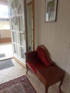 EbenzweierFerienwohnung Gütl am Weg的客厅配有红色椅子和门