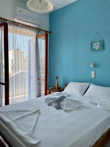 阿吉亚努美利Panorama Rooms的蓝色的卧室设有白色的床和窗户
