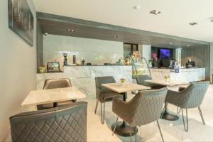 曼谷Hyde Park Hotel Bangkok的一间带桌椅的餐厅和一间酒吧