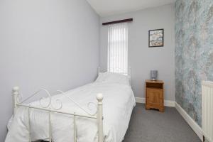 诺丁汉Comfortable 4-Bed House in Hucknall Nottingham的卧室配有白色的床和窗户。