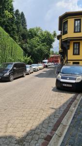 YıldırımCozy Spacious near Green Mosque的一条街道,有汽车停在黄色建筑旁边
