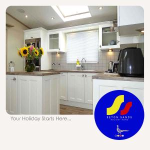 塞顿港Seton Sands Holiday Home的厨房配有白色橱柜和标志,让您的假期从这里开始
