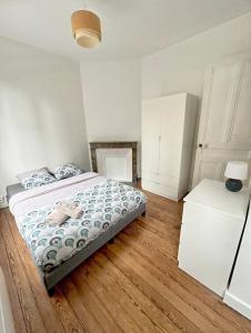 勒阿弗尔Maison Coty - Hypercentre/Plage的一间卧室设有一张大床,铺有木地板