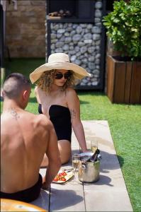 巴尼亚Guest house Wishmore的坐在野餐桌上戴帽子的女人