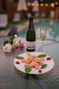 巴尼亚Guest house Wishmore的桌上有一盘虾和一瓶葡萄酒