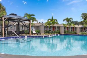 奥兰多Travelodge by Wyndham Kissimmee Orlando的一个带凉亭的大型游泳池