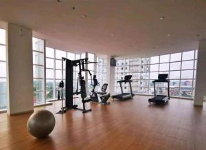 西冷Ilham Apartemen Batch 1的大型客房带窗户,设有健身房和有氧健身器材