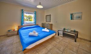 雷夫卡达镇Villa Esperanza by Imagine Lefkada的一间卧室配有蓝色的床和2条毛巾