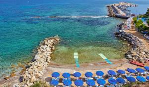 卡斯特拉巴特阿普罗多海水浴Spa度假酒店的海滩上一组带蓝伞的椅子