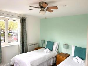 格拉斯顿伯里Inn Glastonbury - Self Catering的一间卧室设有两张床和窗户。