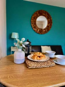 格拉斯顿伯里Inn Glastonbury - Self Catering的一张桌子,上面放着一盘羊角面包和镜子