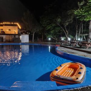南海郡南海海滩酒店的一只橙色的船在晚上坐在游泳池里