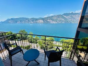 马尔切西内卡门维拉酒店的阳台配有椅子,享有水景