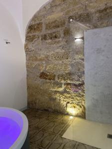 奇尼斯Settegrana Suite con vasca idromassaggio的一间带石墙和卫生间的浴室