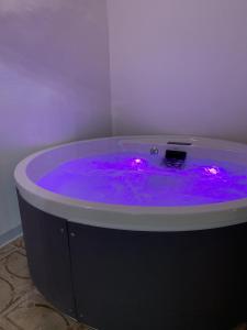 奇尼斯Settegrana Suite con vasca idromassaggio的客房内的紫色浴缸配有灯