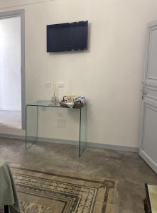 奇尼斯Settegrana Suite con vasca idromassaggio的白色墙壁上的玻璃桌