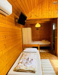 赞考Babett Vendégház的木制客房内的一间卧室,配有一张床