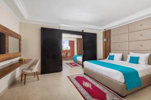 马拉喀什Pickalbatros Aqua Fun Club All inclusive的酒店客房配有两张床和一张书桌