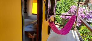 阿布拉奥Recanto das Flores Lofts - Ilha Grande Rj的客房在鲜花阳台上设有吊床