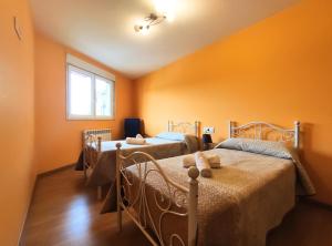 萨里亚Casa-Nova 2的橙色墙壁客房的两张床