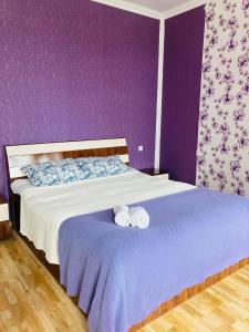 马尔特维利Mira House的紫色卧室配有一张带两张滚毛巾的床