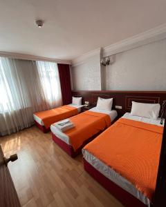 伊斯坦布尔莱德怀特酒店的酒店客房带两张带橙色床单的床
