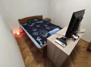 诺维·维诺多尔斯基Aretha apartman i sobe的一间卧室配有一张床和一张书桌上的电视
