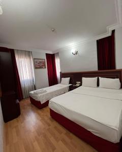伊斯坦布尔莱德怀特酒店的酒店客房,设有两张床和红色窗帘