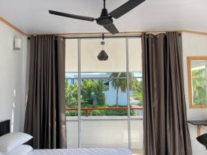 图杜Thoddoo White Sand Inn的一间卧室配有吊扇和窗户。