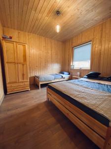 萨比诺瓦Zielona Dolina Sarbinowo的木制客房内的一间卧室配有两张床