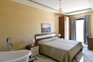 圣劳伦斯Azure W B&B的一间卧室配有一张床、一个浴缸和一个浴缸