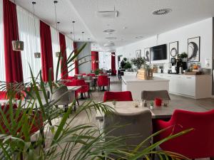 霍夫DORMERO Hotel Hof的一间餐厅,房间内设有红色的椅子和桌子