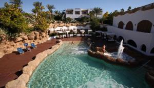 沙姆沙伊赫Suite al Domina Coral Bay , Resort Spa e Casino'的度假村的游泳池,人们在里面玩耍