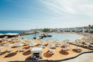沙姆沙伊赫Suite al Domina Coral Bay , Resort Spa e Casino'的一个带遮阳伞和椅子的大型游泳池以及大海